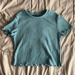 Cropped lettuce-style, sapphire/teal blue short-sleeve shirt.